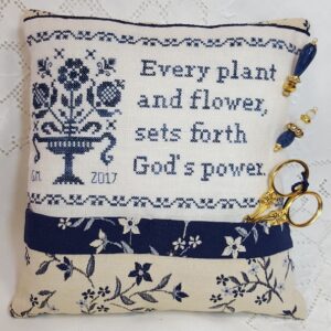 pillow in blue with sentence on God flowers and plants embroidered