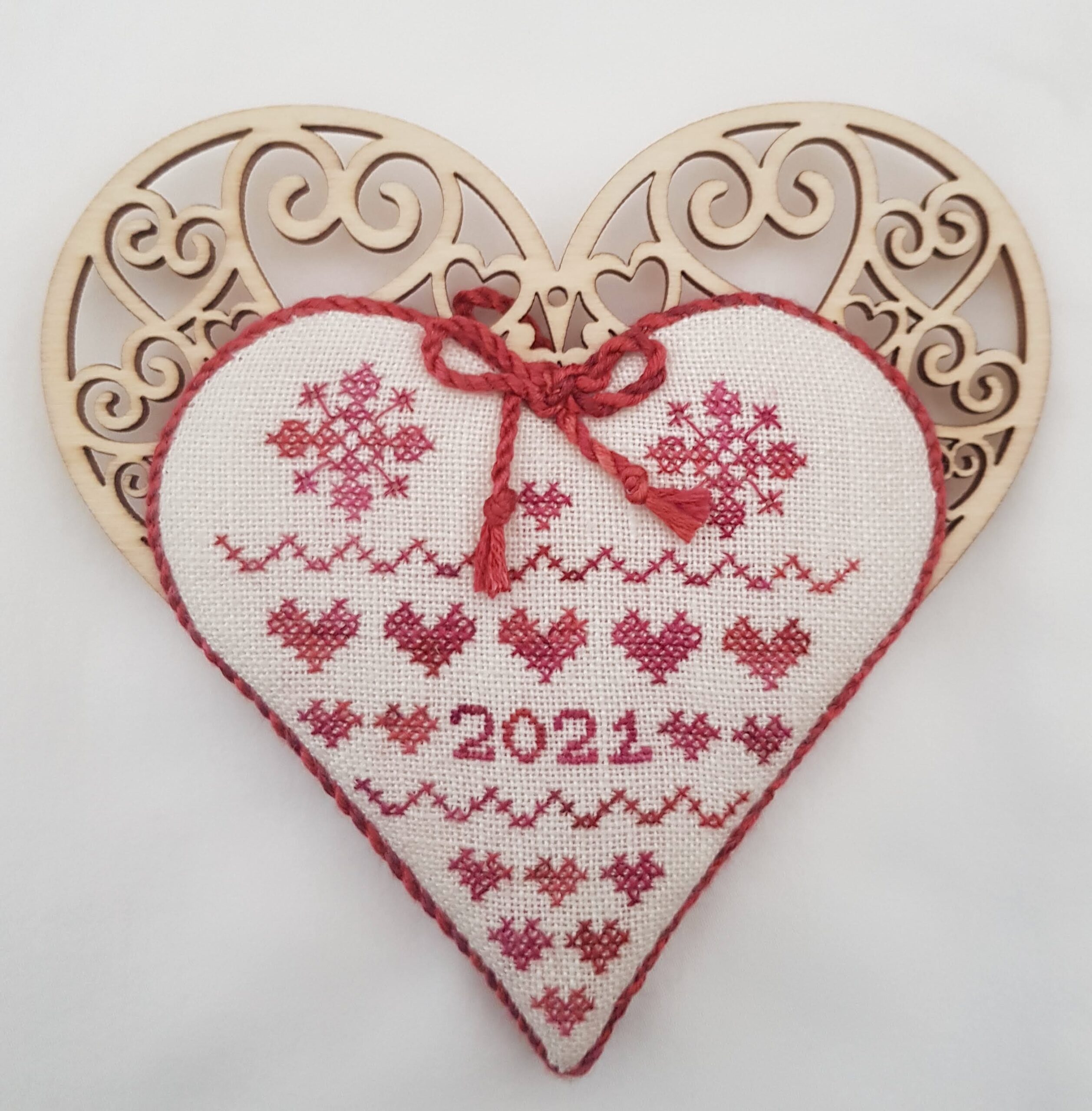 one side wooden heart with stitched red hearts and flowers